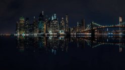 City skyline y Brooklyn Bridge por la noche, Manhattan, Nueva York, América, EE.UU. - foto de stock