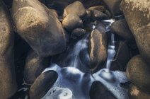 Vista close-up de água que flui através de rochas de granito — Fotografia de Stock