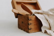 Boîte en bois avec ustensiles de cuisine et serviettes de toilette en lin — Photo de stock