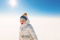 Retrato de uma menina sorridente de pé na neve — Fotografia de Stock