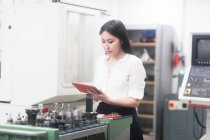Портрет женщины-инженера, стоящей в мастерской с цифровым планшетом — стоковое фото