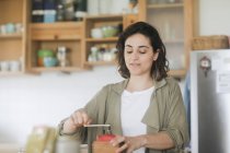 Жінка стоїть на кухні, використовуючи стару кавоварку — стокове фото