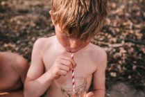 Primer plano de un chico disfrutando de una bebida de verano - foto de stock