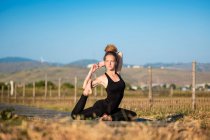 Mulher fazendo uma pose de meia pomba de ioga, O Parque Natural do Estreito, Tarifa, Cádiz, Andaluzia, Espanha — Fotografia de Stock