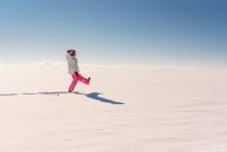 Chica jugando en un paisaje rural nevado - foto de stock
