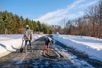Boy and girl playing in the road in the melting snow — Stock Photo