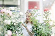 Donna che compra fiori in un mercato — Foto stock