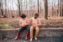 Dois meninos sentados em uma parede desfrutando de uma bebida de verão — Fotografia de Stock