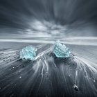 Small icebergs on black sand beach on cloudy day — Stock Photo