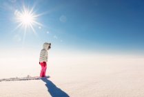 Дівчина стоїть в сніжному сільському пейзажі — стокове фото