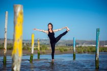 Donna che fa una mano alla posa di yoga alluce sulla spiaggia, Tarifa, Cadice, Andalusia, Spagna — Foto stock