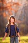 Retrato de uma menina sorridente de pé no jardim, Estados Unidos — Fotografia de Stock