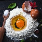 Raw egg and ingredients on a dark background. — Stock Photo