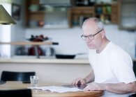 Человек сидит за столом с помощью цифрового планшета — стоковое фото