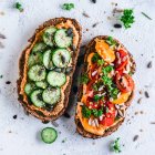 Paprika Hummus toasts with tomato and cucumber — Stock Photo