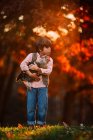 Boy standing outdoor coccolando un pollo, Stati Uniti — Foto stock