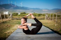 Woman doing a yoga bow pose, The Strait Natural Park, Tarifa, Cadiz, Andalusia, Spain — Stock Photo