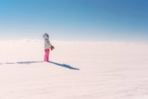 Дівчина стоїть в сніжному сільському пейзажі — стокове фото