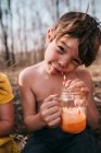 Усміхнений хлопчик п'є апельсиновий поплавок влітку — стокове фото