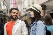 Retrato de una pareja sonriente en una calle de compras de la ciudad - foto de stock