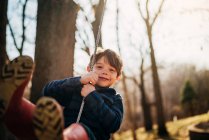 Nahaufnahme Porträt eines lächelnden Jungen auf einer Schaukel — Stockfoto