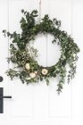 Christmas Wreath hanging on a white door — Stock Photo
