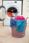 Wäschekorb vor einer Waschmaschine — Stockfoto