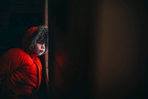 Мальчик в зимней куртке стоит у входной двери — стоковое фото