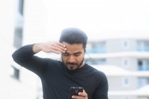 Mann hört beim Joggen Musik auf seinem Smartphone — Stockfoto