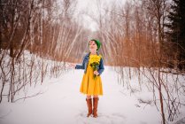 Дівчина стоїть на снігу тримає купу квітів — стокове фото