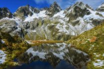 Vista panorámica de las reflexiones de la montaña en un lago alpino, Susten, Suiza - foto de stock