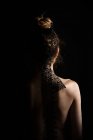 Rear view of a naked woman wearing a lace ribbon in her hair — Stock Photo