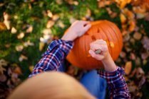 Junge schnitzt einen Halloween-Kürbis im Garten, USA — Stockfoto