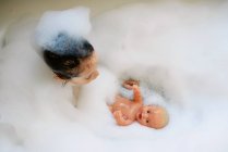 Chica joven jugando en un baño de burbujas - foto de stock