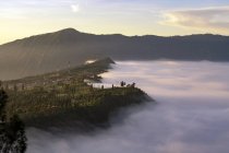 Низкие облака в деревне Семоро Лаванг на рассвете. Национальный парк Бромо Тенггер Семеру, Восточная Ява, Индонезия — стоковое фото