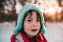 Портрет усміхненої дівчини, що стоїть на снігу — стокове фото