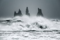 Волны, разбивающиеся о морские стопки в океане, Исландия — стоковое фото