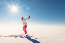 Girl jumping mid air in a snowy rural landscape — Stock Photo