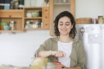 Frau steht mit alter Kaffeemühle in der Küche — Stockfoto