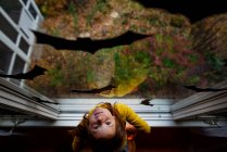 Vue aérienne d'une fille debout près d'une fenêtre décorée avec des décorations de chauve-souris pour Halloween, États-Unis — Photo de stock