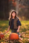Ragazza sorridente che intaglia una zucca di Halloween in giardino, Stati Uniti — Foto stock