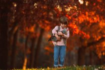 Boy standing outdoor cuddling a chicken, Estados Unidos — Fotografia de Stock