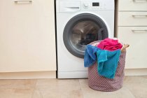Panier à linge devant une machine à laver — Photo de stock