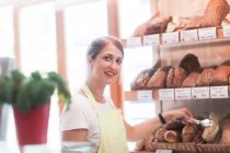 Sorridente assistente di vendita in una panetteria — Foto stock