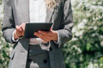 Femme d'affaires debout à l'extérieur en utilisant une tablette numérique — Photo de stock