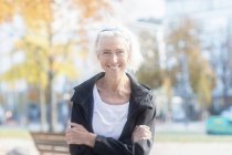Retrato de uma mulher sorridente em pé no parque, Alemanha — Fotografia de Stock