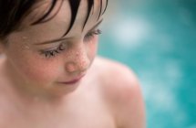 Retrato de un niño de pie junto a una piscina - foto de stock