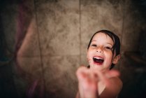 Fille debout dans la douche riant — Photo de stock