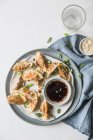 Gyoza dumplings with dipping sauce, top view — Stock Photo