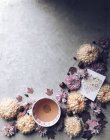 Chrysanthemenblüten und eine Tasse Kräutertee und Hallo-Karte — Stockfoto